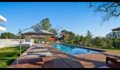 Ipe decks and glass tile mosaic swimming pool.