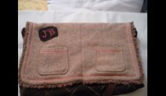 This messenger bag was made from a skirt for the body, and the pockets, flap, and handle, are made from a blazer.