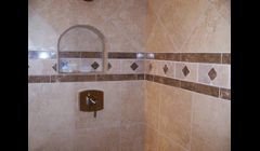Shower done in Marazzi Tile materials and a light emperador marble border.