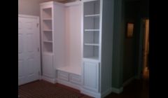 A built in shelving unit with bench seat