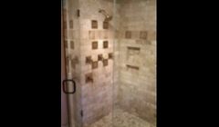 Travertine corner shower with bench seat.