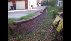 Tie wall removed and replaced with a versa lok wall system without disturbing the concrete driveway.