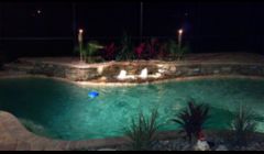 Custom Pool with natural stone and fountain. Caribben Blue Pebble Tec Finish