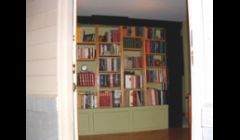 A bookcase I built that acts as a room divider --- It stands on its own. Behind it is a buffet.